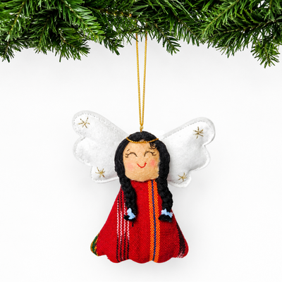 Decorative angel ornament with long hair and red outfit hanging from a tree branch.